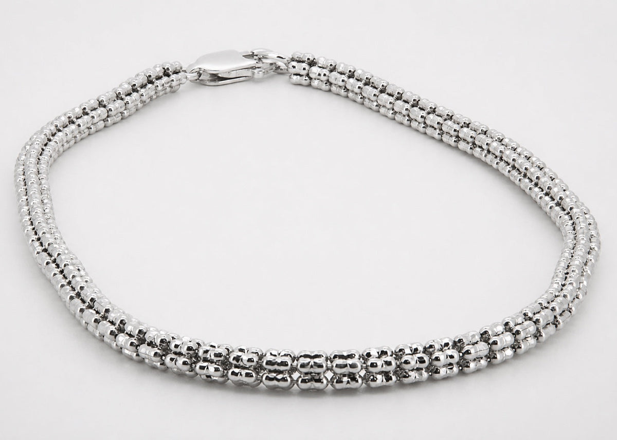 Angled view of the three-row beaded 14K white-gold bracelet and lobster clasp