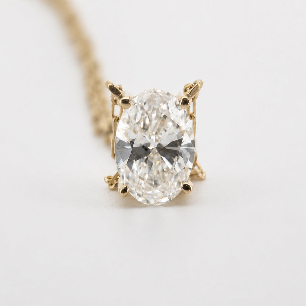 Front view of an oval solitaire pendant necklace in 14K yellow gold