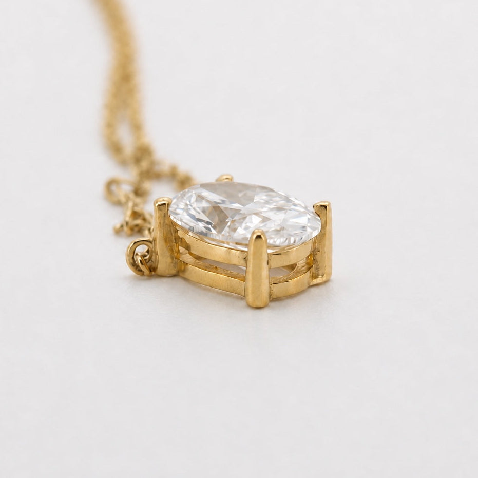 Side view of an oval solitaire pendant necklace in 14K yellow gold