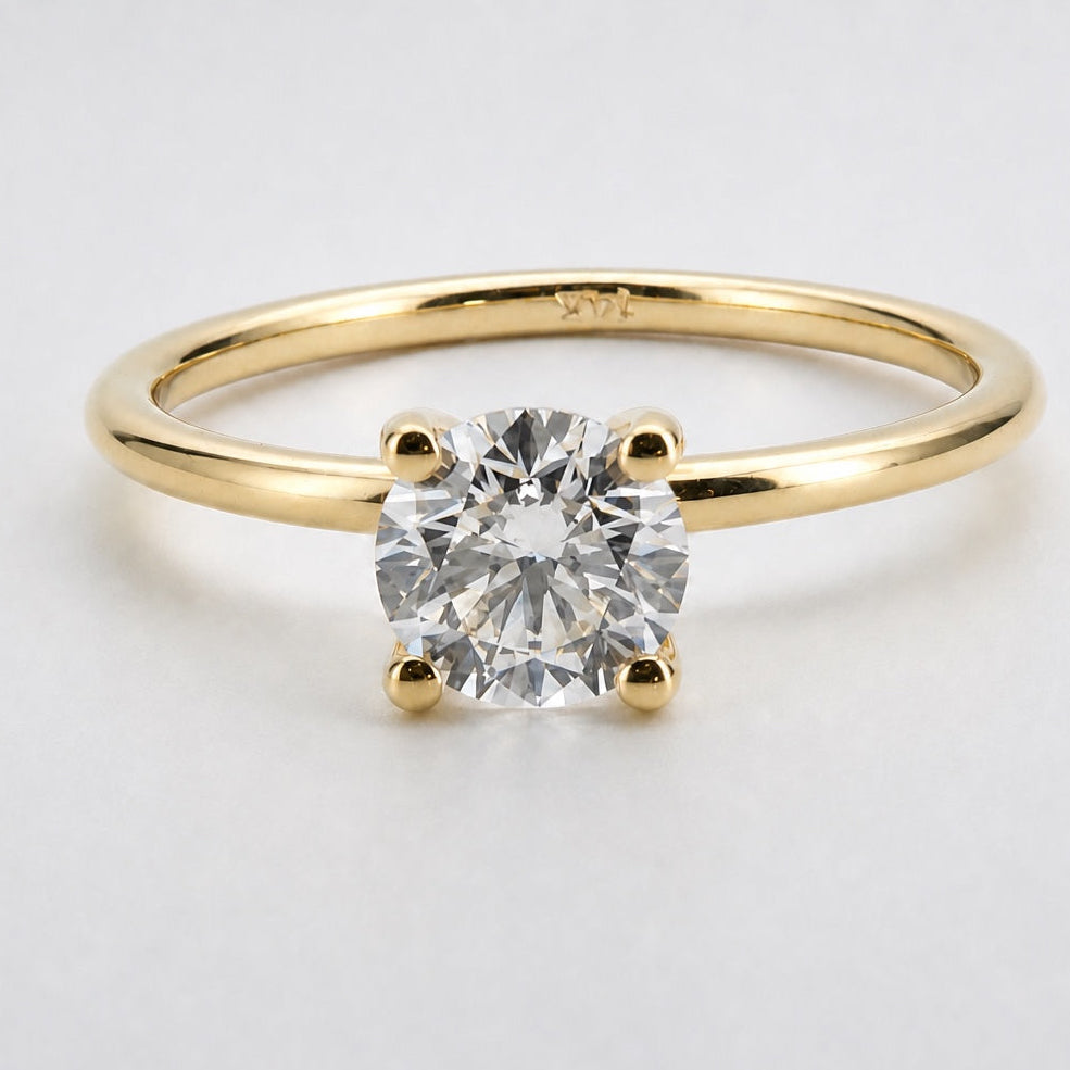 Front view of a round solitaire engagement ring in 14K yellow gold