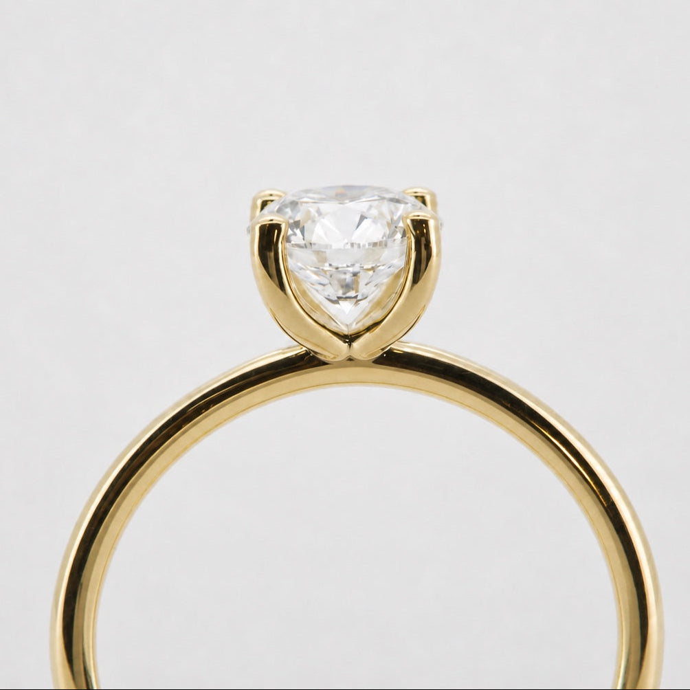 Side profile of a round solitaire engagement ring in 14K yellow gold
