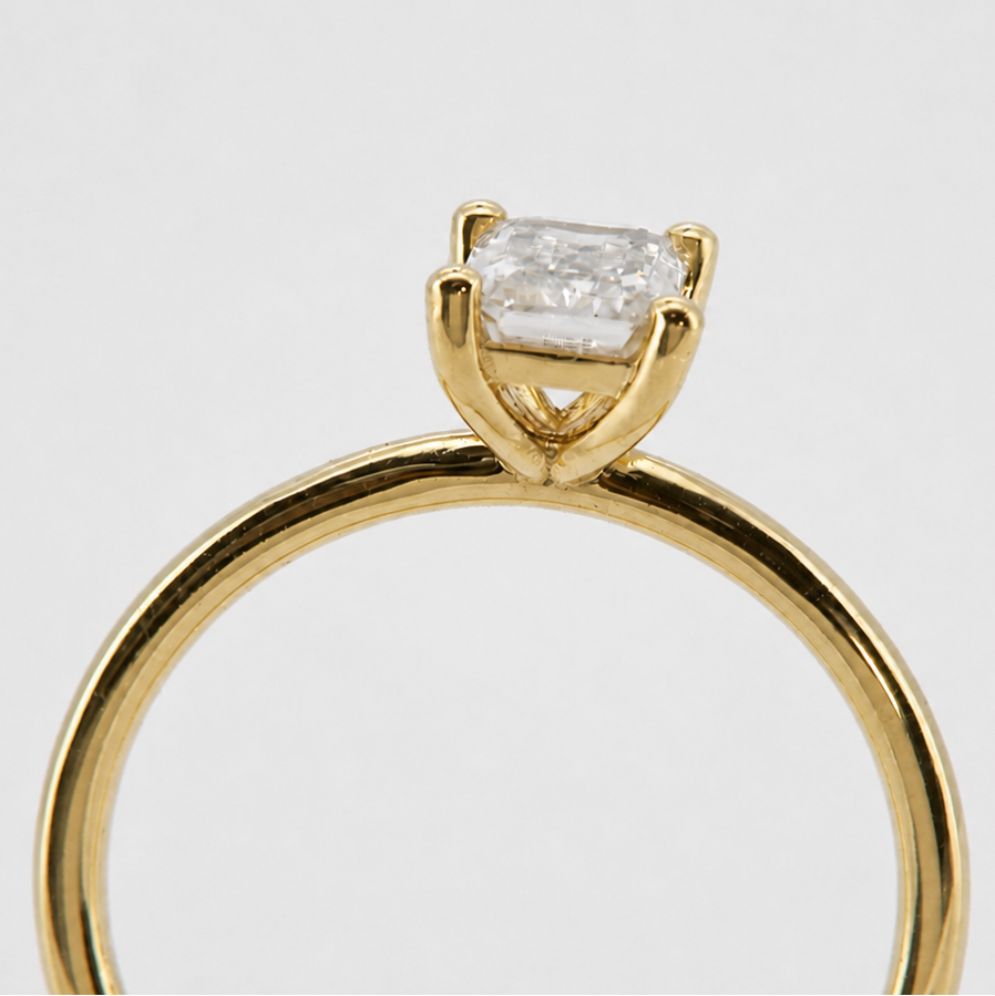 Yellow-gold visualization of the emerald-cut solitaire engagement ring, end-on basket profile #Metal_14K Yellow Gold