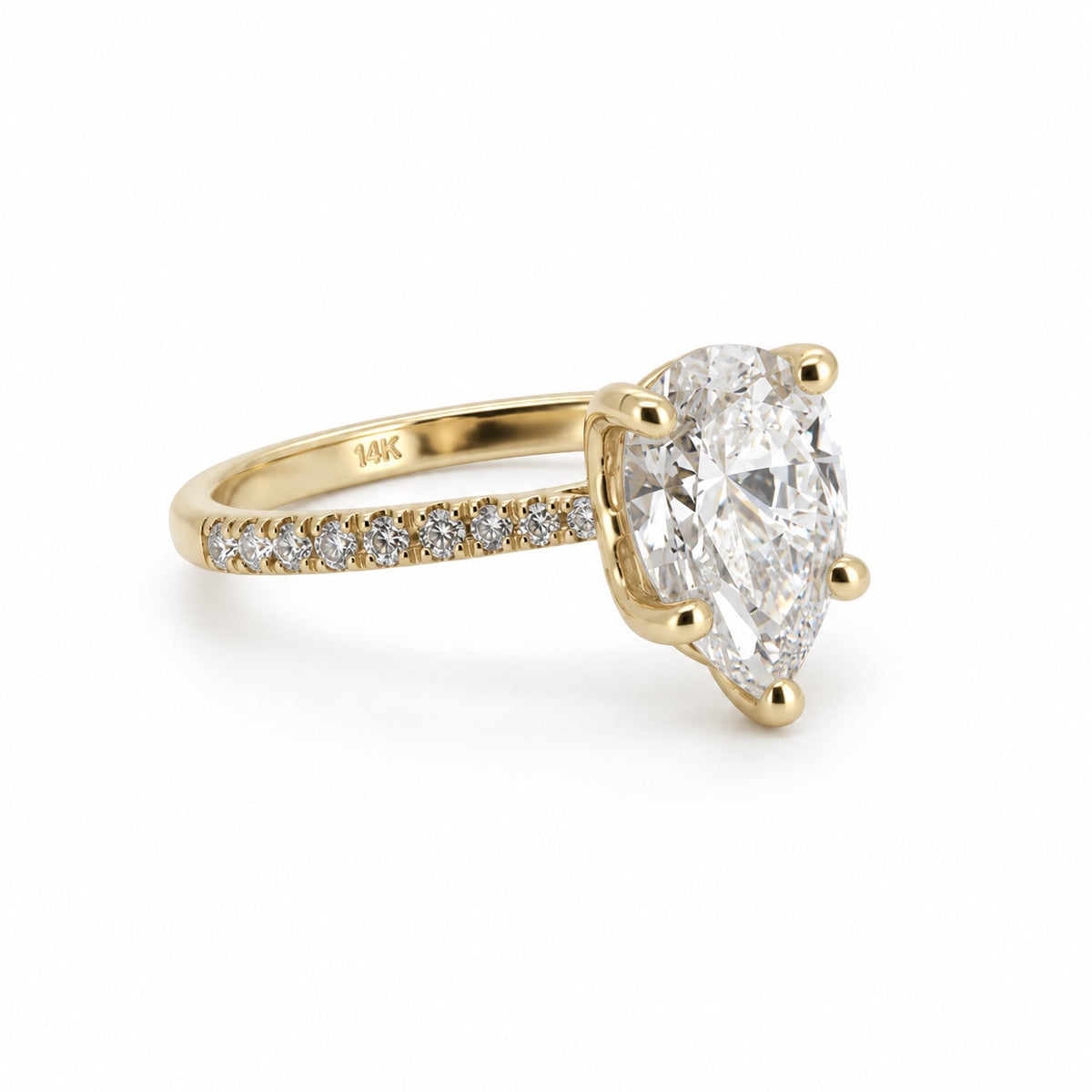 Pear solitaire engagement ring with stone-set band in 14K yellow gold, three-quarter view